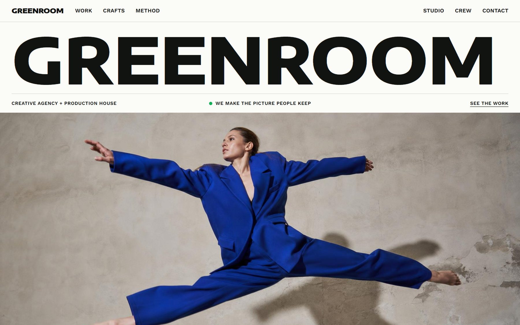 A creative agency website in one of Doko's designs: its name in large type above a photo of a dancer mid-leap in a cobalt suit.